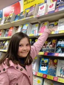 Ellie pointing out the last book on the shelf